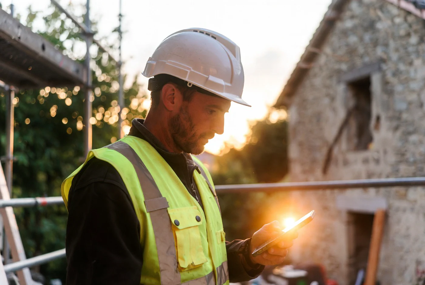 Artisan du bâtiment cherchant des chantiers près de chez lui sur son téléphone en 2026
